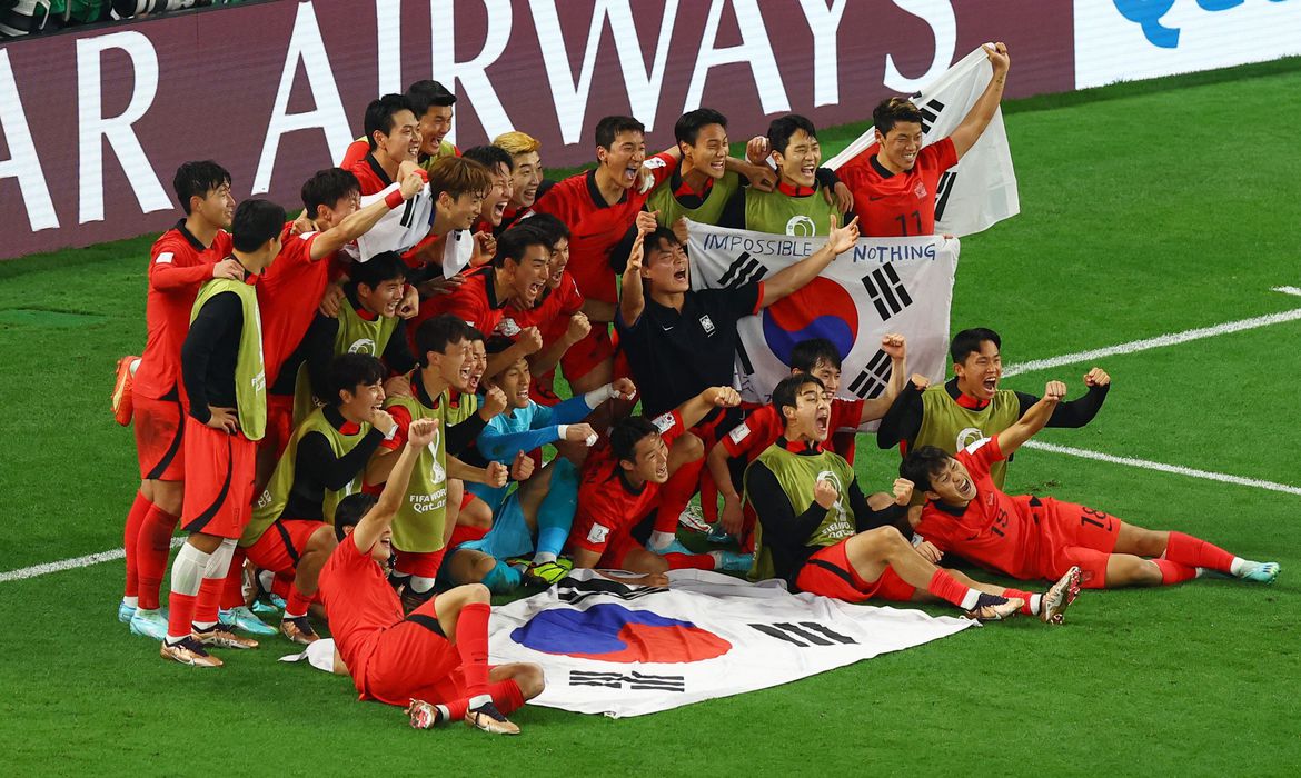 Coreanos posam para a foto da classificação após vitória sobre Portugal. (REUTERS)